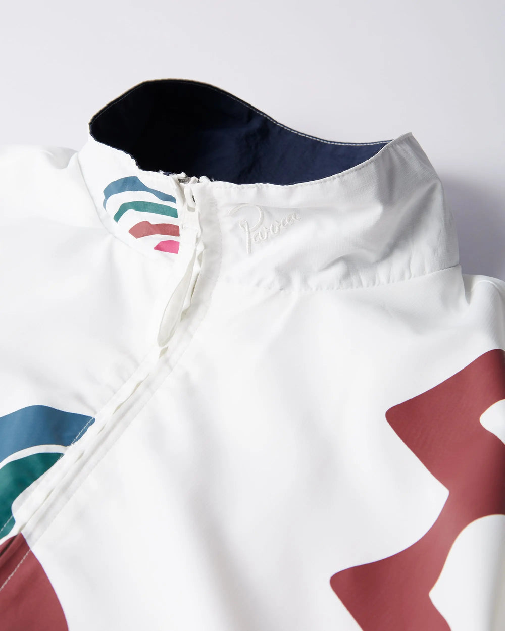 Close-up of the collar and zipper detailing on the white byParra Tennis Maybe? Track Jacket.