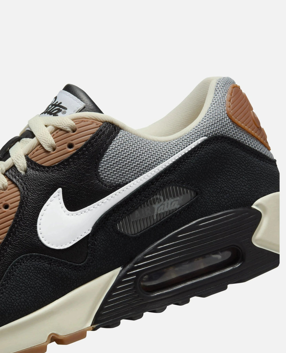 Close-up detail of Patta x Nike Air Max 90 SP sneaker in textured black leather and grey mesh.